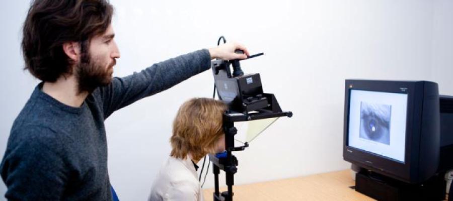 Picture of man looking at screen while woman gets eyes tracked