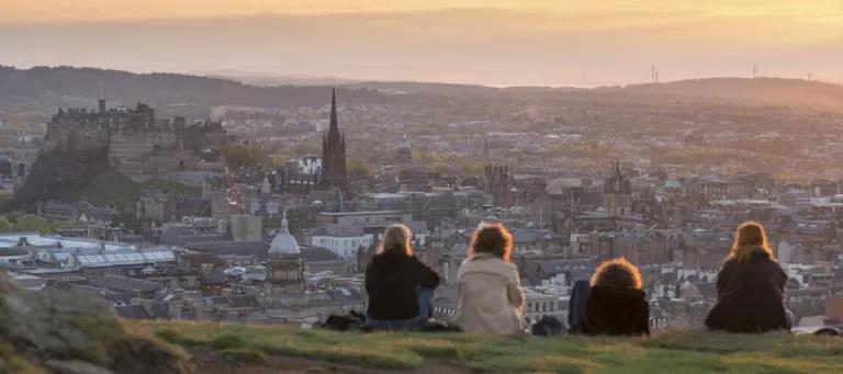 Students sitting looking out over Edinburgh from Salisbury Crags